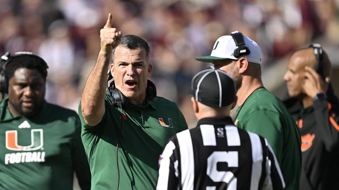 Dec 20, 2025; College Station, TX, USA; Miami Hurricanes head coach Mario Cristobal talks with an official during the second half of the first round game of the CFP National Playoff against the Texas A&M Aggies at Kyle Field. Mandatory Credit: Jerome Miron-Imagn Images