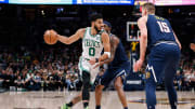 Mar 20, 2022; Denver, Colorado, USA; Boston Celtics forward Jayson Tatum (0) controls the ball against Denver Nuggets forward Will Barton (5) as center Nikola Jokic (15) defends in the first quarter at Ball Arena. Mandatory Credit: Isaiah J. Downing-USA TODAY Sports