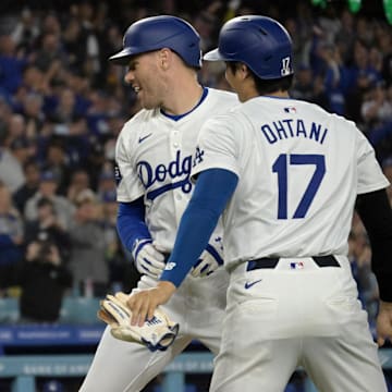 May 20, 2024; Los Angeles, California, USA;  Los Angeles Dodgers first baseman Freddie Freeman (5) is greeted at the plate by shortstop Mookie Betts (50) and designated hitter Shohei Ohtani (17) after hitting a grand slam home run in the third inning against the Arizona Diamondbacks at Dodger Stadium. 