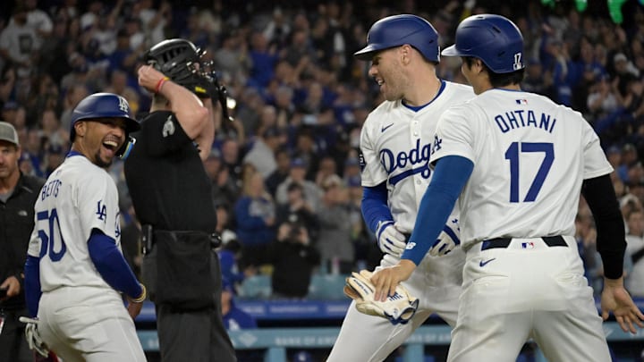 May 20, 2024; Los Angeles, California, USA;  Los Angeles Dodgers first baseman Freddie Freeman (5) is greeted at the plate by shortstop Mookie Betts (50) and designated hitter Shohei Ohtani (17) after hitting a grand slam home run in the third inning against the Arizona Diamondbacks at Dodger Stadium. 