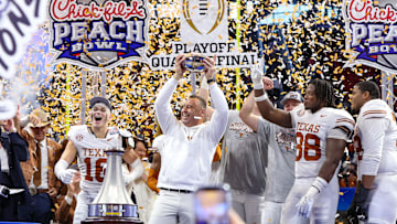 Jan 1, 2025; Atlanta, GA, USA; Texas Longhorns head coach Steve Sarkisian and defensive back Michael Taaffe (16) and linebacker Barryn Sorrell (88) and offensive lineman Kelvin Banks Jr. (78) hold up the trophy after a victory over the Arizona State Sun Devils in the Peach Bowl at Mercedes-Benz Stadium. Mandatory Credit: Brett Davis-Imagn Images