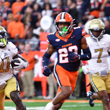 Sep 7, 2024; Syracuse, New York, USA; Georgia Tech Yellow Jackets running back Jamal Haynes (11) scores a touchdown ahead of Syracuse Orange defensive back Devin Grant (23) in the fourth quarter at the JMA Wireless Dome. Mandatory Credit: Mark Konezny-Imagn Images