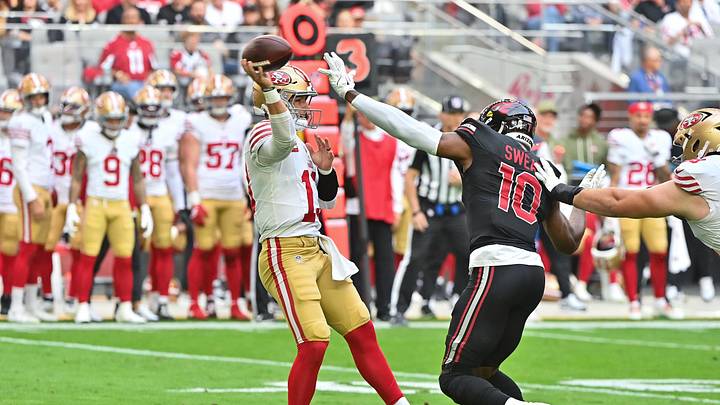 Nov 16, 2025; Glendale, Arizona, USA; San Francisco 49ers quarterback Brock Purdy (13) throws the ball in the first half while being defended by Arizona Cardinals outside linebacker Josh Sweat (10) in the first half at State Farm Stadium. Mandatory Credit: Matt Kartozian-Imagn Images