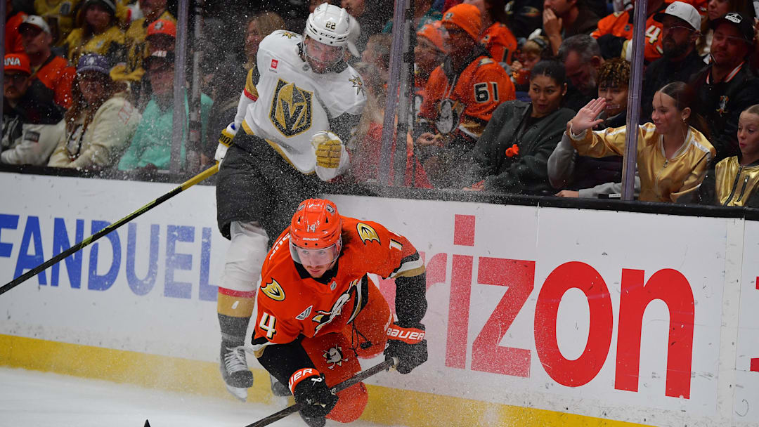 May 8, 2026; Anaheim, California, USA; Vegas Golden Knights right wing Cole Smith (22) hits Anaheim Ducks defenseman Drew Helleson (14) while playing for the puck during the third period in game three of the second round of the 2026 Stanley Cup Playoffs at Honda Center. Mandatory Credit: Gary A. Vasquez-Imagn Images
