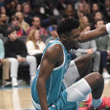 Dec 16, 2024; Charlotte, North Carolina, USA;  Charlotte Hornets forward Brandon Miller (24) signals for someone to help him up after a fall during the second half against the Philadelphia 76ers at the Spectrum Center. Mandatory Credit: Sam Sharpe-Imagn Images