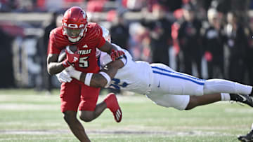Nov 25, 2023; Louisville, Kentucky, USA;  Louisville Cardinals running back Jawhar Jordan (25) runs the ball against Kentucky Wildcats linebacker Trevin Wallace (32) during the first quarter at L&N Federal Credit Union Stadium. Mandatory Credit: Jamie Rhodes-Imagn Images