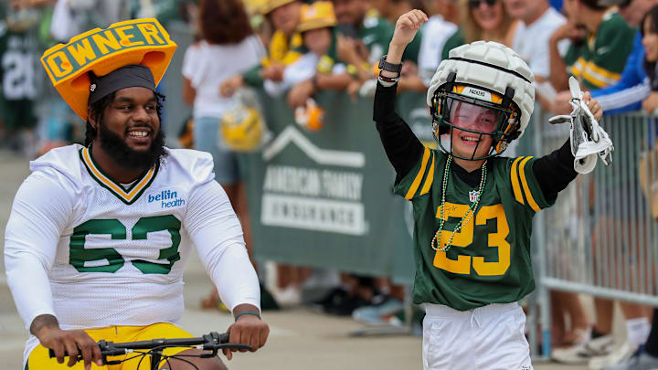 A young Green Bay Packers fan celebrates after trading their cheesehead for Packers offensive lineman Rasheed Walker’s helmet in the DreamDrive before practice on Tuesday, July 23, 2024, at Lambeau Field in Green Bay, Wis. 
Tork Mason/USA TODAY NETWORK-Wisconsin