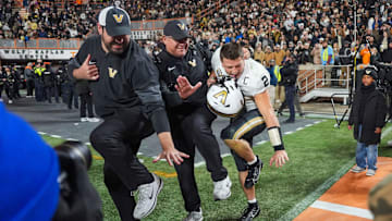Vanderbilt quarterback Diego Pavia (2) poses as the Heisman trophy after winning a NCAA football game between Tennessee and Vanderbilt at Neyland Stadium in Knoxville, Tenn., on Nov. 29, 2025.