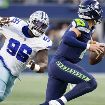 Dallas Cowboys defensive tackle Neville Gallimore (96) pressures Seattle Seahawks quarterback Drew Lock (2) during the second quarter of a preseason game at Lumen Field in 2023.