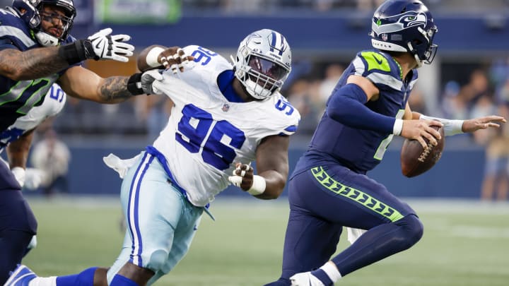 Dallas Cowboys defensive tackle Neville Gallimore (96) pressures Seattle Seahawks quarterback Drew Lock (2) during the second quarter of a preseason game at Lumen Field in 2023.