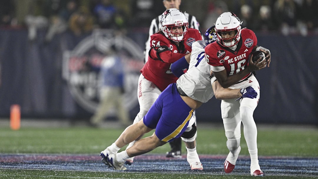 Dec 28, 2024; Annapolis, MD, USA;  East Carolina Pirates defensive lineman J.D. Lampley (9) sacks North Carolina State Wolfpack quarterback CJ Bailey (16) during the first half of the Go Bowling Military Bowl at Navy-Marine Corps Memorial Stadium. Mandatory Credit: Tommy Gilligan-Imagn Images