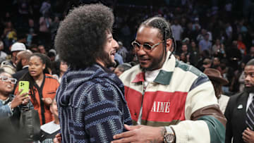 Oct 1, 2024; Brooklyn, New York, USA; Former NFL quarterback Colin Kaepernick embraces former NBA forward Carmelo Anthony after game two of the 2024 WNBA Semi-finals between the Las Vegas Aces and the New York Liberty at Barclays Center. Mandatory Credit: Wendell Cruz-Imagn Images