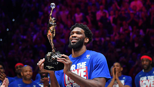 Joel Embiid hoists the MVP Trophy.