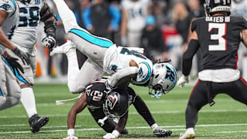 Jan 5, 2025; Atlanta, Georgia, USA; Carolina Panthers running back Mike Boone (34) is upended by Atlanta Falcons cornerback Dee Alford (20) during the second half at Mercedes-Benz Stadium. Mandatory Credit: Dale Zanine-Imagn Images