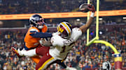 Nov 30, 2025; Landover, Maryland, USA; Washington Commanders wide receiver Treylon Burks (13) makes a catch for a touchdown defended by Denver Broncos cornerback Riley Moss (21) in the third quarter of the game at Northwest Stadium. Mandatory Credit: Peter Casey-Imagn Images