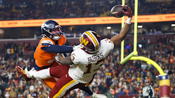 Nov 30, 2025; Landover, Maryland, USA; Washington Commanders wide receiver Treylon Burks (13) makes a catch for a touchdown defended by Denver Broncos cornerback Riley Moss (21) in the third quarter of the game at Northwest Stadium. Mandatory Credit: Peter Casey-Imagn Images