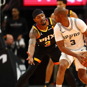 Dec 3, 2024; Phoenix, Arizona, USA; San Antonio Spurs guard Chris Paul (right) controls the ball against Phoenix Suns guard Bradley Beal in the second half of an NBA Cup game at Footprint Center. Mandatory Credit: Mark J. Rebilas-Imagn Images