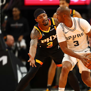 Dec 3, 2024; Phoenix, Arizona, USA; San Antonio Spurs guard Chris Paul (right) controls the ball against Phoenix Suns guard Bradley Beal in the second half of an NBA Cup game at Footprint Center. Mandatory Credit: Mark J. Rebilas-Imagn Images