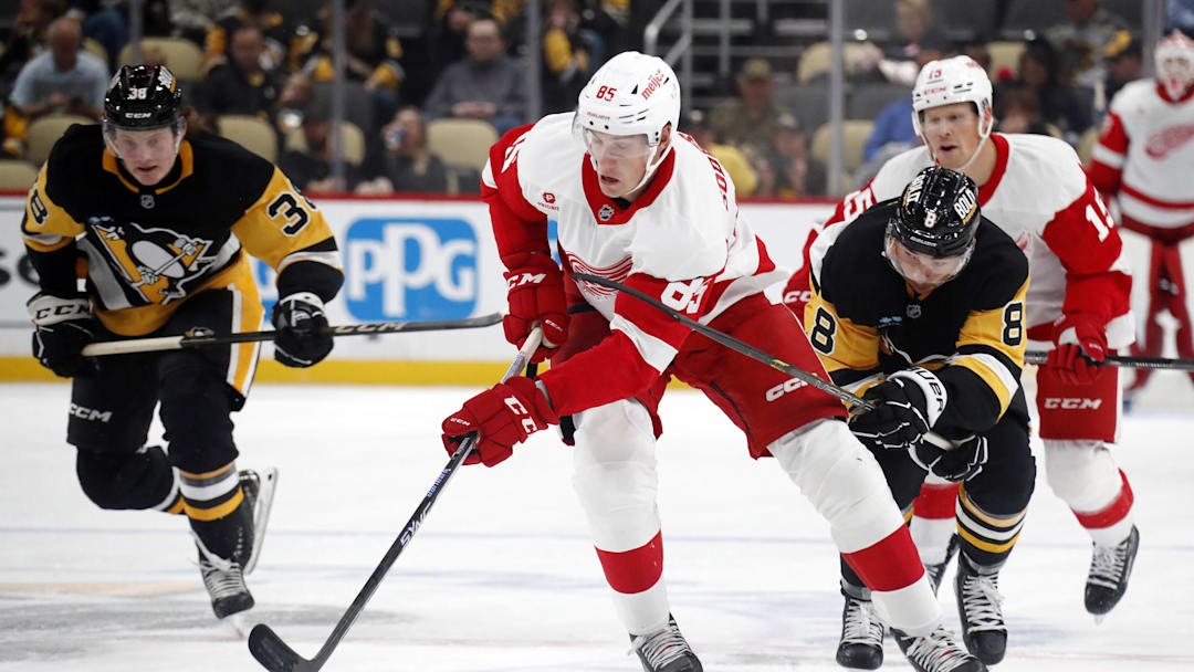 Oct 1, 2024; Pittsburgh, Pennsylvania, USA;  Detroit Red Wings left wing Elmer Soderblom (85) skates up ice with the puck ahead of Pittsburgh Penguins left wing Michael Bunting (8) during the second period at PPG Paints Arena. Mandatory Credit: Charles LeClaire-Imagn Images