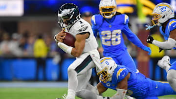 Dec 8, 2025; Inglewood, California, USA; Philadelphia Eagles quarterback Jalen Hurts (1) runs against Los Angeles Chargers linebacker Daiyan Henley (0) in overtime at SoFi Stadium. Mandatory Credit: Gary A. Vasquez-Imagn Images