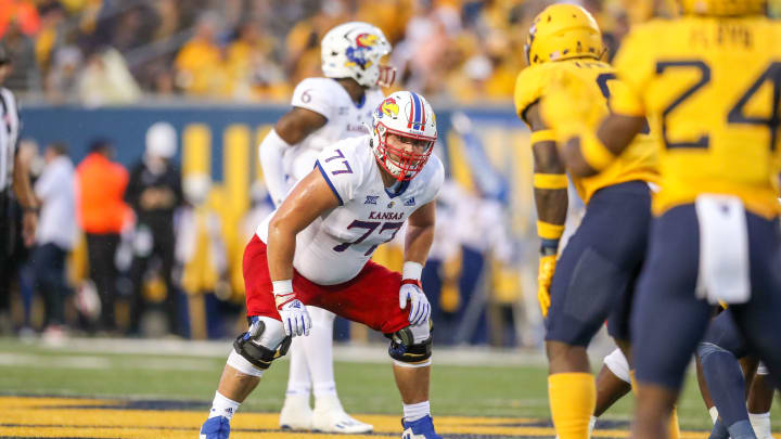 Sep 10, 2022; Morgantown, West Virginia, USA; Kansas Jayhawks offensive lineman Bryce Cabeldue (77) pauses before a snap during the second quarter against the West Virginia Mountaineers at Mountaineer Field at Milan Puskar Stadium. Mandatory Credit: Ben Queen-USA TODAY Sports