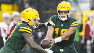 Nov 3, 2024; Green Bay, Wisconsin, USA;  Green Bay Packers quarterback Jordan Love (10) hands the football off to running back Josh Jacobs (8) during the first quarter against the Detroit Lions at Lambeau Field.