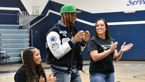 Jaeden Moore, center, verbally committed on Aug. 17, 2022 to play college football at the University of Oregon.