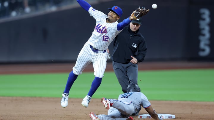 Jun 11, 2024; New York City, New York, USA; Miami Marlins second baseman Otto Lopez (61) steals second base as New York Mets shortstop Francisco Lindor (12) can't catch the throw from catcher Francisco Alvarez (not pictured) allowing Lopez to go to third base during the ninth inning at Citi Field. Mandatory Credit: Brad Penner-USA TODAY Sports