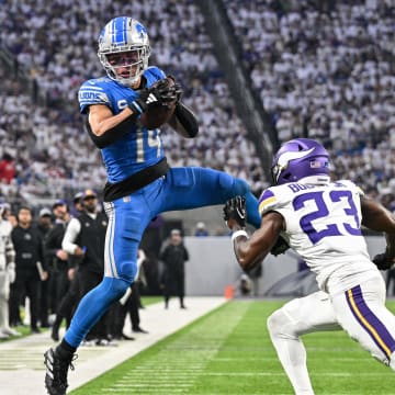 Dec 24, 2023; Minneapolis, Minnesota, USA; Detroit Lions wide receiver Amon-Ra St. Brown (14) catches a pass as Minnesota Vikings cornerback Andrew Booth Jr. (23) defends during the game at U.S. Bank Stadium. 