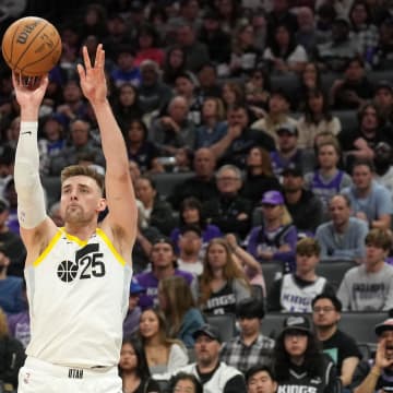 Mar 31, 2024; Sacramento, California, USA; Utah Jazz center Micah Potter (25) shoots against Sacramento Kings forward Sasha Vezenkov (7) during the third quarter at Golden 1 Center. Mandatory Credit: Darren Yamashita-USA TODAY Sports