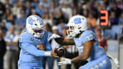 Nov 8, 2025; Chapel Hill, North Carolina, USA; North Carolina Tar Heels quarterback Gio Lopez (7) hands the ball off to running back Davion Gause (37) in the second quarter at Kenan Stadium. Mandatory Credit: Bob Donnan-Imagn Images