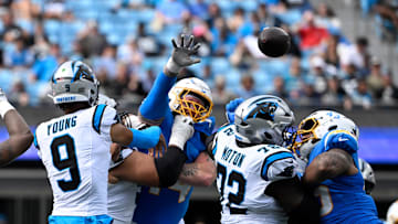 Sep 15, 2024; Charlotte, North Carolina, USA; Carolina Panthers quarterback Bryce Young (9) passes the ball as Los Angeles Chargers defensive tackle Scott Matlock (44) pressures in the fourth quarter at Bank of America Stadium. Mandatory Credit: Bob Donnan-Imagn Images
