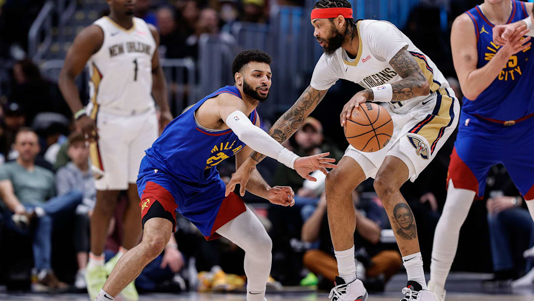 Jan 12, 2024; Denver, Colorado, USA; New Orleans Pelicans forward Brandon Ingram (14) controls the ball as Denver Nuggets guard Jamal Murray (27) defends in the third quarter at Ball Arena. Mandatory Credit: Isaiah J. Downing-Imagn Images
