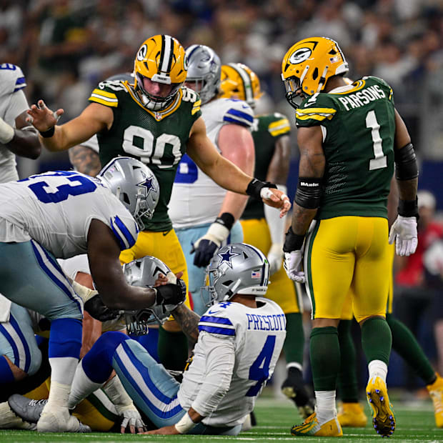 Green Bay Packers defensive end Micah Parsons (1) stands over Dallas Cowboys quarterback Dak Prescott.