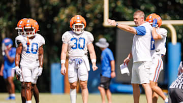 Florida Gators head coach Billy Napier gestures while Florida Gators wide receiver Tank Hawkins (10) and Florida Gators wide receiver Taylor Spierto (30) watch during fall football practice at Heavener Football Complex at the University of Florida in Gainesville, FL on Tuesday, August 12, 2025. [Matt Pendleton/Gainesville Sun]