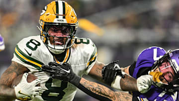 Green Bay Packers running back Josh Jacobs (8) stiff-arms Minnesota Vikings cornerback Byron Murphy Jr. 