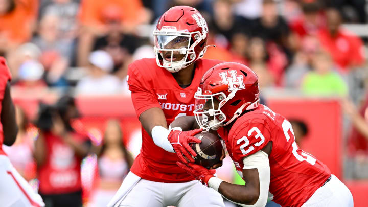 Nov 18, 2023; Houston, Texas, USA; Houston Cougars quarterback Donovan Smith (1) hands off the ball to running back Parker Jenkins (23) during the first quarter against the Oklahoma State Cowboys at TDECU Stadium. Mandatory Credit: Maria Lysaker-USA TODAY Sports