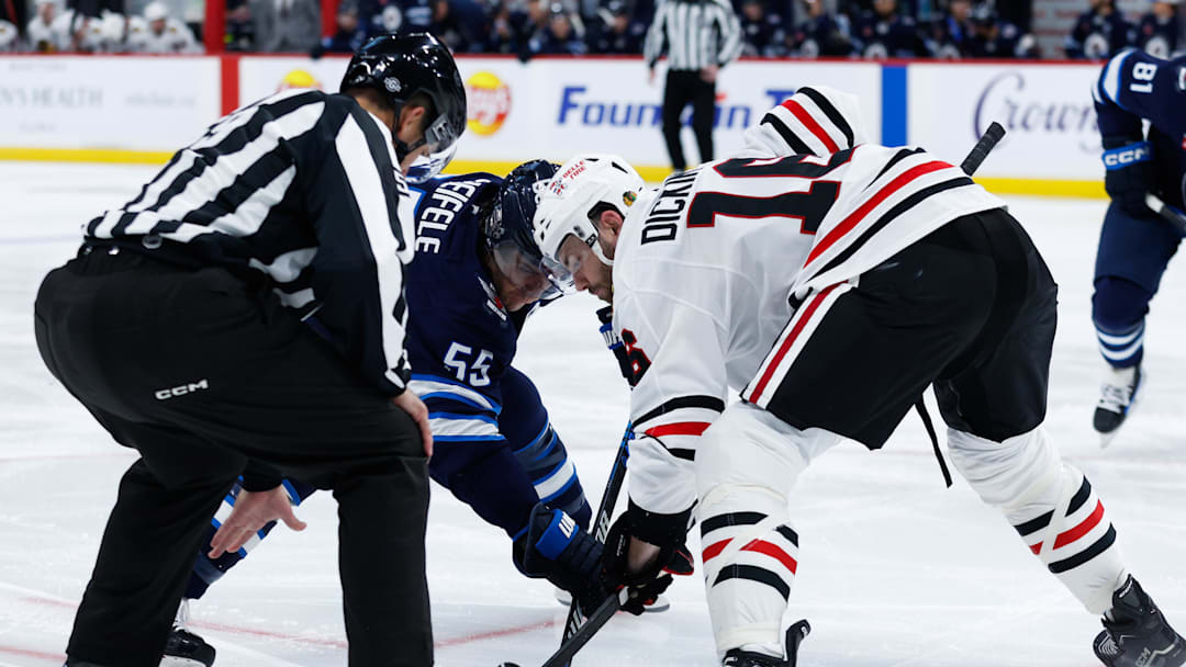 Oct 11, 2024; Winnipeg, Manitoba, CAN;  Winnipeg Jets forward Mark Scheifele (55) faces off against Chicago Blackhawks forward Jason Dickinson (16) during the second period at Canada Life Centre. Mandatory Credit: Terrence Lee-Imagn Images
