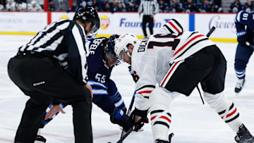 Oct 11, 2024; Winnipeg, Manitoba, CAN;  Winnipeg Jets forward Mark Scheifele (55) faces off against Chicago Blackhawks forward Jason Dickinson (16) during the second period at Canada Life Centre. Mandatory Credit: Terrence Lee-Imagn Images