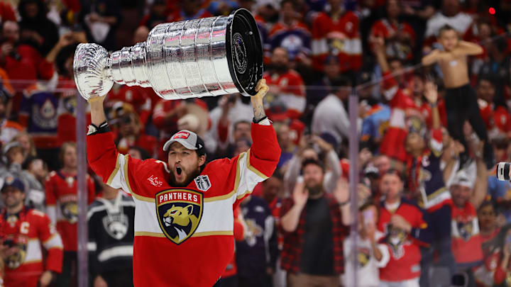 Jun 24, 2024; Sunrise, Florida, USA; Florida Panthers forward Carter Verhaeghe (23) hoists the Stanley Cup after defeating the Edmonton Oilers in game seven of the 2024 Stanley Cup Final at Amerant Bank Arena. Mandatory Credit: Sam Navarro-Imagn Images Jun 24, 2024; Sunrise, Florida, USA; Florida Panthers forward Carter Verhaeghe (23) hoists the Stanley Cup after defeating the Edmonton Oilers in game seven of the 2024 Stanley Cup Final at Amerant Bank Arena. Mandatory Credit: Sam Navarro-Imagn Images
