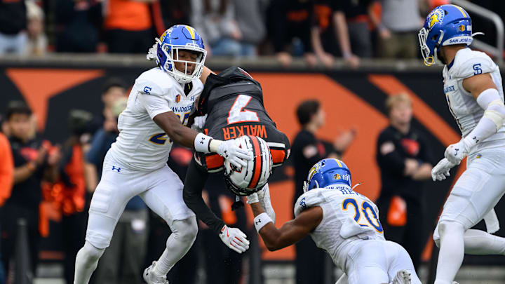 Nov 9, 2024; Corvallis, Oregon, USA; Oregon State Beavers wide receiver Trent Walker (7) is upended by San Jose State Spartans defensive back Michael Dansby (25) and defensive back Isiah Revis (20) after a catch during the third quarter at Reser Stadium. Mandatory Credit: Craig Strobeck-Imagn Images
