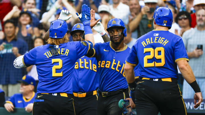 Seattle Mariners outfielder Victor Robles (second from right) high-fives Justin Turner (2) after a grand-slam home run by Turner against the Philadelphia Phillies on Friday.