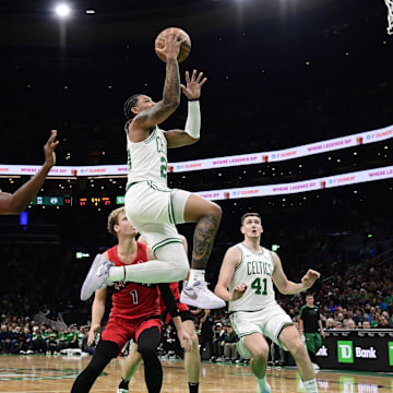 Oct 13, 2024; Boston, Massachusetts, USA;  Boston Celtics guard JD Davison (20) drives to the basket past Toronto Raptors forward Jonathan Mogbo (2) during the first half at TD Garden. Mandatory Credit: Bob DeChiara-Imagn Images