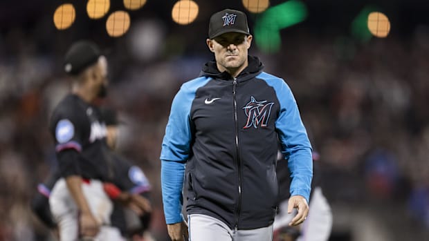 Miami Marlins manager Skip Schumaker (45) walks off the field in a black and teal jacket and black Marlins hat