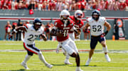 Sep 6, 2025; Raleigh, North Carolina, USA; North Carolina State Wolfpack quarterback CJ Bailey (11) runs with the football guarded by Virginia Cavaliers safety Devin Neal (27) during the first half of the game at Carter-Finley Stadium. Mandatory Credit: Jaylynn Nash-Imagn Images