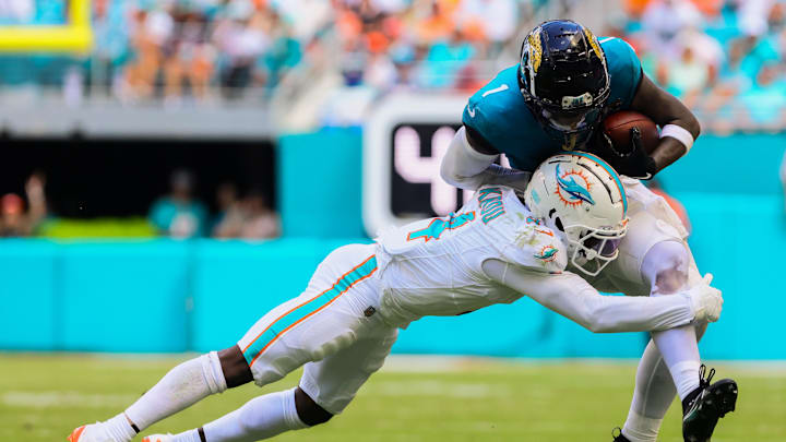 Sep 8, 2024; Miami Gardens, Florida, USA; Jacksonville Jaguars running back Travis Etienne Jr. (1) runs with the football against Miami Dolphins cornerback Kader Kohou (4) during the third quarter at Hard Rock Stadium. 