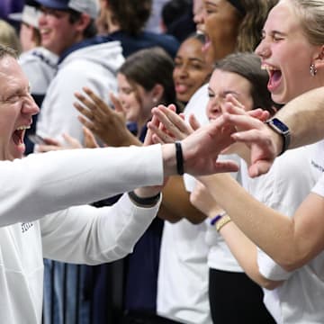 Penn State men's basketball coach Mike Rhoades high-fives students following a Big Ten game vs. the Ohio State Buckeyes at Bryce Jordan Center.
