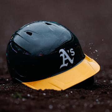 Apr 4, 2025; Denver, Colorado, USA; An Athletics helmet sits in the dirt after being thrown in the tenth inning against the Colorado Rockies at Coors Field. Mandatory Credit: Isaiah J. Downing-Imagn Images
