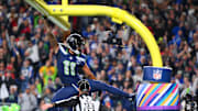 Oct 20, 2025; Seattle, Washington, USA; Seattle Seahawks wide receiver Jaxon Smith-Njigba (11) celebrates on the goal post after a touchdown during the first quarter against the Houston Texans at Lumen Field. Mandatory Credit: Steven Bisig-Imagn Images