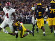 Jan 1, 2024; Pasadena, CA, USA; Alabama Crimson Tide quarterback Jalen Milroe (4) is tackled by Michigan Wolverines defensive back Rod Moore (9) during overtime in the 2024 Rose Bowl college football playoff semifinal game at Rose Bowl.